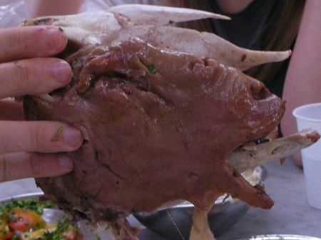 The white part behind the purple-colored head is bones of the skull, which the well-cooked meat is literally falling from