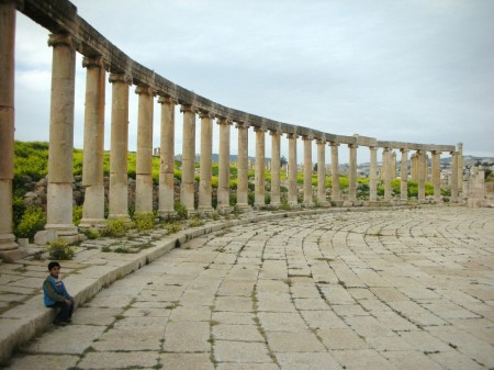 A little boy paused from his game of tag with his siblings to rest in the massive Oval Plaza