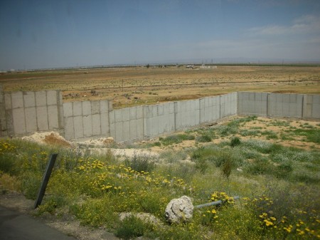 How welcoming is a cement wall for your first view of Syria? Surprisingly enough, the Jordanian side is the greener side of the fence