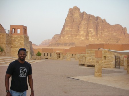 Moses poses next to Rum's most famous mountain group, the Seven Pillars of Wisdom