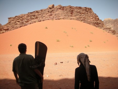Silas and Mahdi ponder the best way to tackle a giant sand mountain
