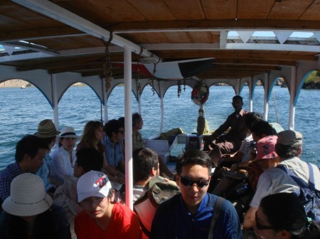 Mahmoud guides the ferry's rudder as our expanded group heads towards the Island