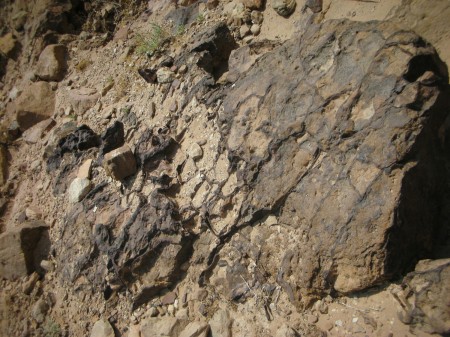 Popped-bubble volcanic rocks trapped in the wadi, which might have been first carved by a volcano, before the water...